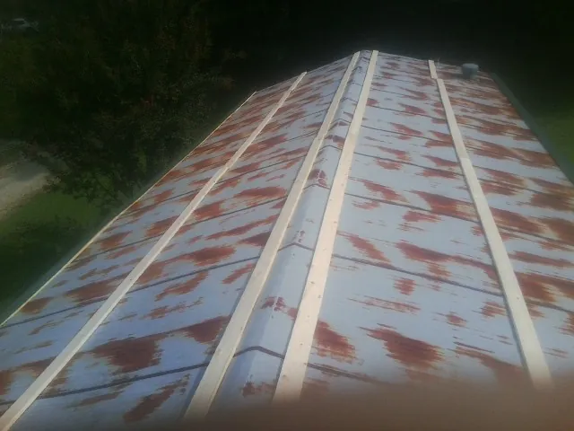 Rusted metal roof panels with new wood purlins before replacement — Storm Damage Roof Repair in Marble Falls by Roofing Brothers