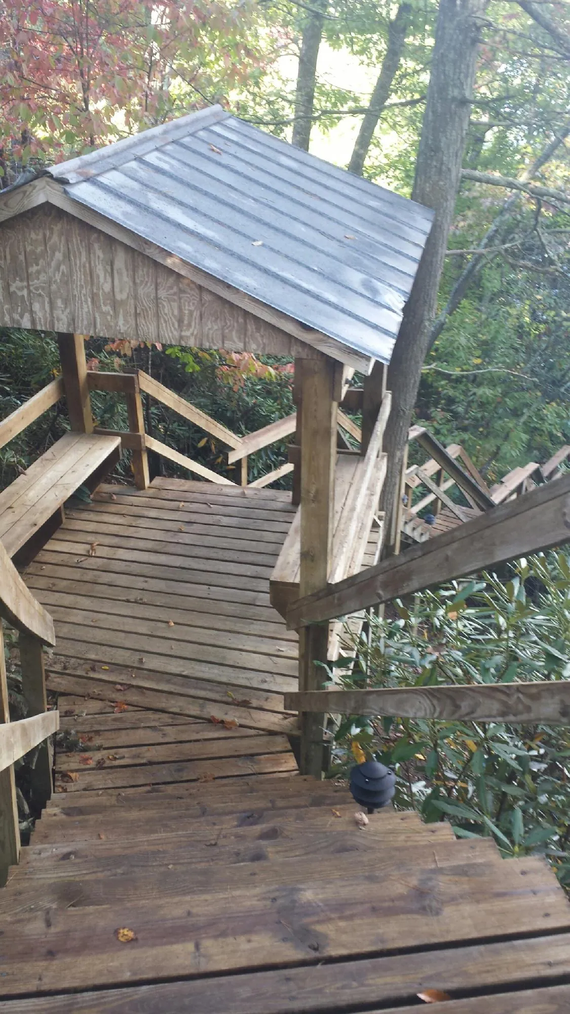 Metal roofed shelter over wooden steps on a wooded walkway — Skylight Repair & Installation work by our crew in Marble Falls