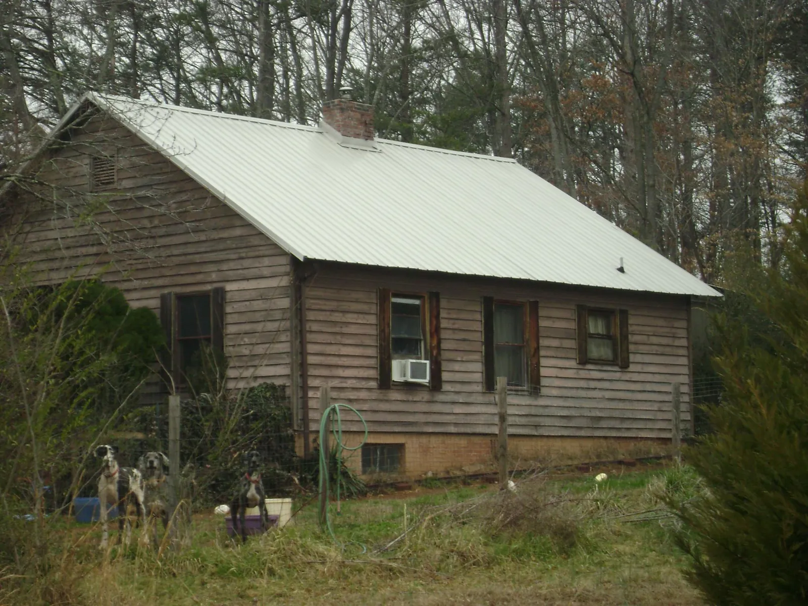 White metal roof on an old wood sided farmhouse, from a Metal Roof Installation job in Marble Falls